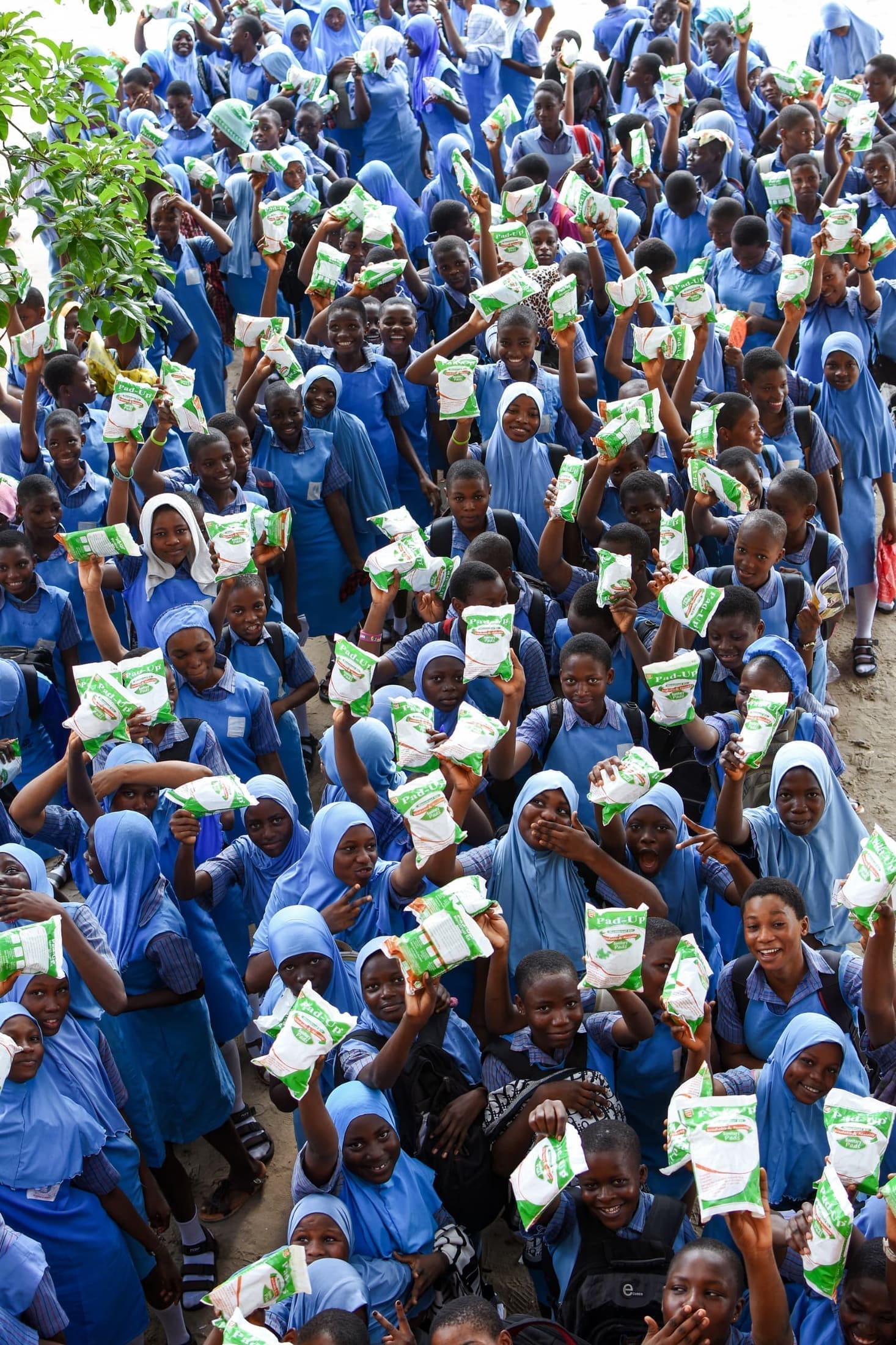 Schoolgirls holding up Pad-Up sanitary pad packs