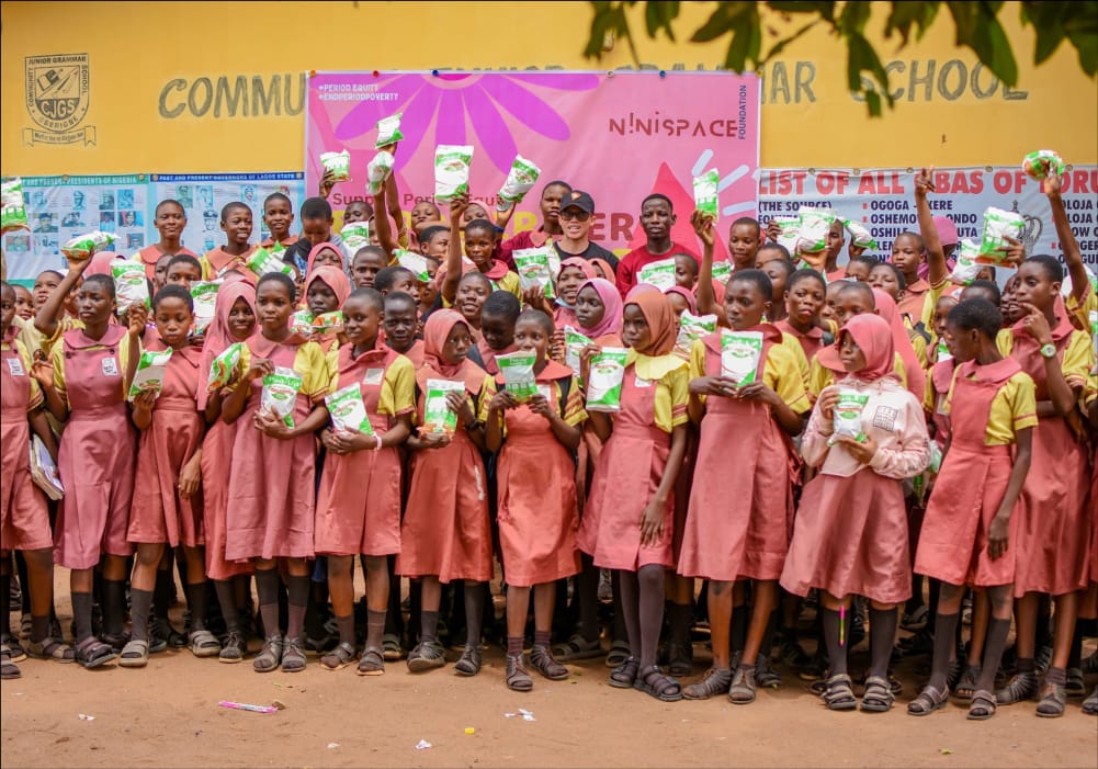 Secondary school students holding Pad-Up kits at a school outreach